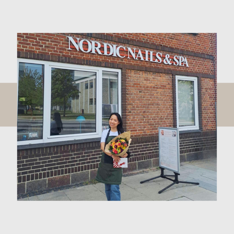 Medarbejder med blomster foran den nye Nordic Nails og Spa salon i Shoppen Aalborg.
