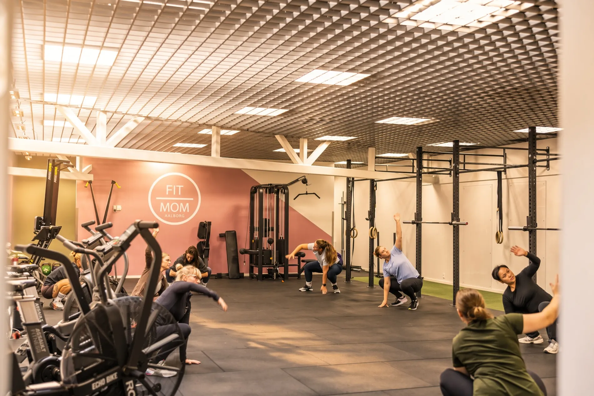 Kvinder der træner i de lyse og moderne fitnesslokaler hos FitMom Aalborg i Shoppen.