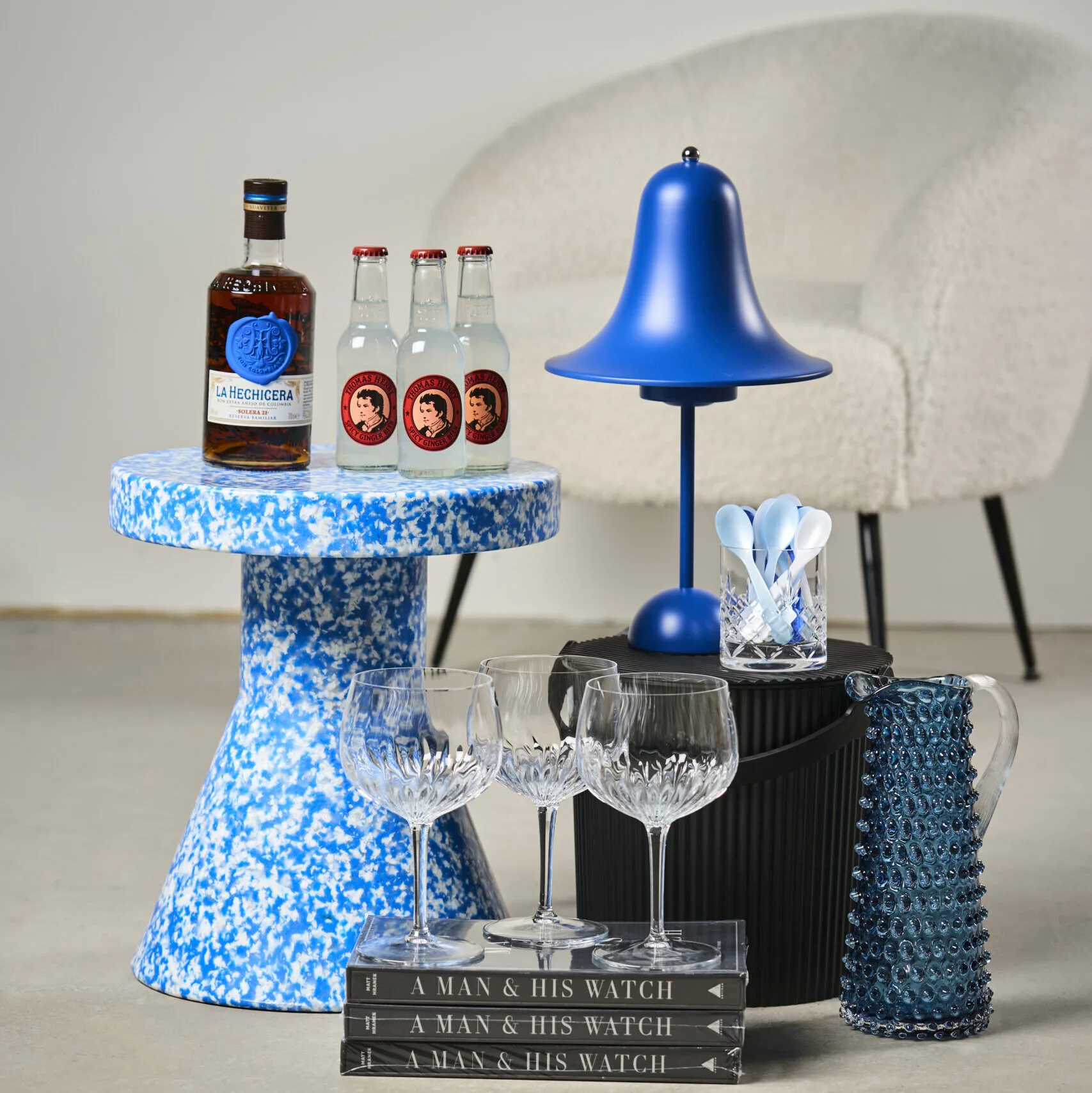 Stilfuldt boliginteriør fra Bahne med blå designlampe, glasvarer og moderne dekoration til hjemmet.