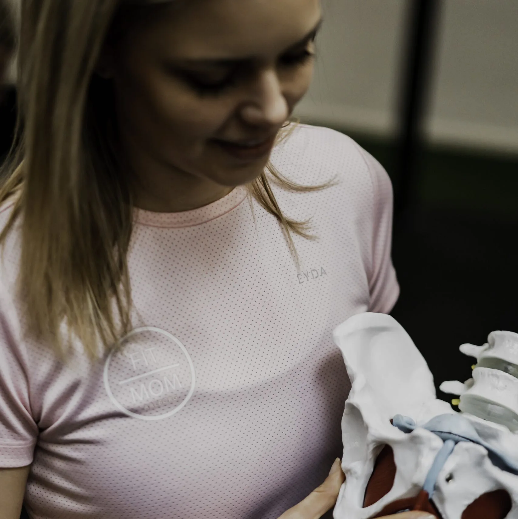 Fysioterapeut fra FitMom Aalborg kigger på en anatomisk model af et bækken.